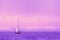 Beautiful sunrise. Sailing boat with a white sail on the calm sea