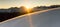 Beautiful sunrise in snowy mountain landscape. Sunbeams illuminating unspoiled powder snow. Alps, Switzerland.