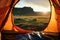 Beautiful sunrise view from the tent. Tourist admiring scenic morning landscape from inside the tent at campsite. Breathtaking