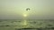 Beautiful sunset above sea with parachute surfing player