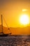 Beautiful sunset on the Aegean Sea with mountains and a sailboat. Seascape, travel and nature concept