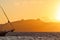 Beautiful sunset on the Aegean Sea with mountains and a sailboat. Seascape, travel and nature concept