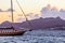 Beautiful sunset on the Aegean Sea with mountains and a sailboat. Seascape, travel and nature concept