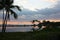 A beautiful sunset in Anaehoomalu Bay, Hawaii, being reflected in a lake surrounded by Palm Trees and tropical plants