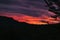 Beautiful sunset on the background of the cloudy sky and high mountains, bright red sunset