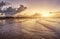 Beautiful sunset on the beach with water reflections, seagulls on the sand and windmills on background