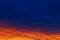 Beautiful sunset. Colorful dramatic sky at sunset. Layered rain clouds. Bright blue orange background