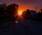 Beautiful sunset on the dusty street in front of the sun. Pink and orange sunset in the countryside