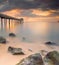 Beautiful sunset of a jetty at Pulau Sayak with rocks and smooth water shot in long exposure