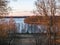 Beautiful sunset landscape over the lake, charming evening colors, tree trunks in the foreground