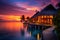 Beautiful sunset in Maldives with palm trees and water bungalows, sunset. Picturesque summer sunset in Maldives. Luxury resort