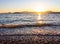 Beautiful sunset on the Mediterranean coast with islands and mountains. Stones on the beach lit by sunlight