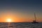 Beautiful sunset in Oia, Santorini, seen from the sea with silhouette of catamaran.