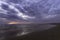 Beautiful sunset over the Atlantic Ocean at Costa da Caparica beach in Lisbon, Portugal. Dramatic sky and clouds in the background