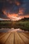 Beautiful sunset over Autumn Fall lake with crystal clear reflections with wooden planks floor