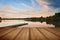 Beautiful sunset over Autumn Fall lake with crystal clear reflections with wooden planks floor