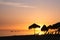 Beautiful sunset over the beach with palm umbrellas