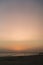 Beautiful sunset over a calm sandy beach with the moon in the sky