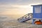 Beautiful sunset over the calm sea on a cloudy hot summer evening. Visible wooden lifeguard house in blue.