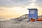 Beautiful sunset over the calm sea on a cloudy hot summer evening. Visible wooden lifeguard house in blue.