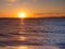 Beautiful sunset over calm seas and empty beach - small islands in the background