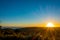 Beautiful sunset over the Hauraki Gulf, with trees and hills silhouetted in the foreground. Taken on the beach at