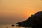 Beautiful sunset over the ocean and cliffs in corfu, greece soft orange color