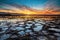 Beautiful sunset over the ocean with rocky beach and tidal pools in the foreground