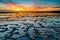 Beautiful sunset over the ocean with rocky beach and tidal pools in the foreground