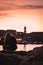 Beautiful sunset over the old town of Dubrovnik. Small local harbour in front of the city, woman in black clothes sitting on a