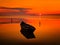 Beautiful sunset over water and silhouette of fishing boat