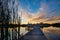 Beautiful sunset reflecting on the water at the public boat landing and dock with bench on Little Moon Lake, Barron County WI