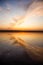 Beautiful sunset with reflection on the lake, clounds in shape of wings. Calm water, vertical shot