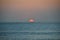 Beautiful sunset with a sailing boat at Jimbaran beach