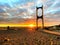 Beautiful sunset at sea maritime bridge gate in the sun light  beach people walking romantic couple stay on sand reflection on sea