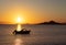 Beautiful sunset on the sea with the silhouette of a boat and mountains in the background. Vacation scene in Mar Menor, Murcia,