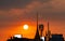 Beautiful sunset sky over the city. Silhouette temple building and telecommunication tower. Antenna on sunset sky background.