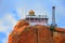 Beautiful sunset view of ancient Hindu Siva Temple at the top of barren rock against the background of cloudy blue sky in Trichy