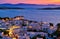 Beautiful sunset view of famous traditional white windmills, Mykonos, Cyclades, Greece. Whitewashed houses, colorful sky
