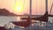 Beautiful sunset view from seaside city, boats at dock, cruise ship on horizon