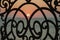 A beautiful Sunset is visible through a cast-iron openwork lattice. The phenomenon of diffraction during the passage of rays throu