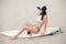 beautiful surfer in bikini sitting on surfboard on sandy