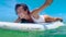 Beautiful surfer girl sitting on surfboard smiling In the water. Slow Motion