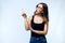 Beautiful surprised young woman with eyeglasses showing and pointing over white background.