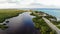 Beautiful swampy colourful colorful blue green lake with green trees and road and beach to the right