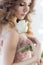 Beautiful sweet girl bride in a wedding dress with a pink air big curls and evening make-up, studio shot