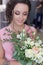 Beautiful sweet girl bridesmaid preparing for the wedding of a friend in the pink evening dress with evening hairstyle and bright