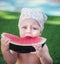 Beautiful sweet girl in a kerchief eats watermelon