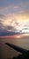 A beautiful symbolic bright background. Alarming autumn seascape. Silhouette peoples on a stone pier.