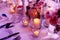 A beautiful table arrangment of lighted candles, flowers and colorful mood lighting